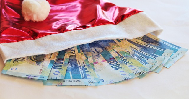 A red bag with white trim with 100 dollar bills fanned sticking out of it